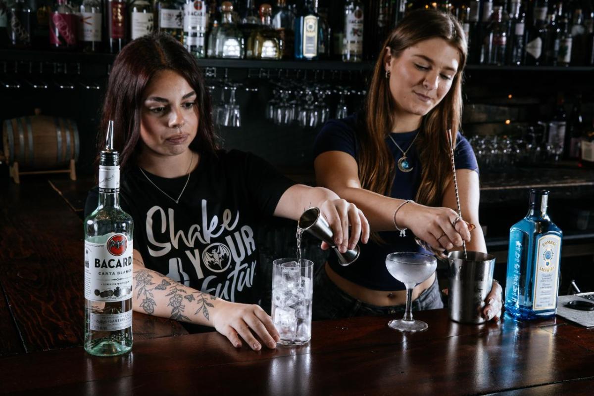 Two people mixing drinks