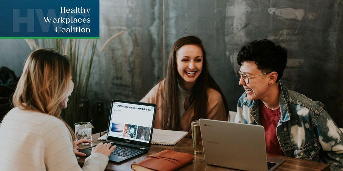 Three people sat at a table on laptops