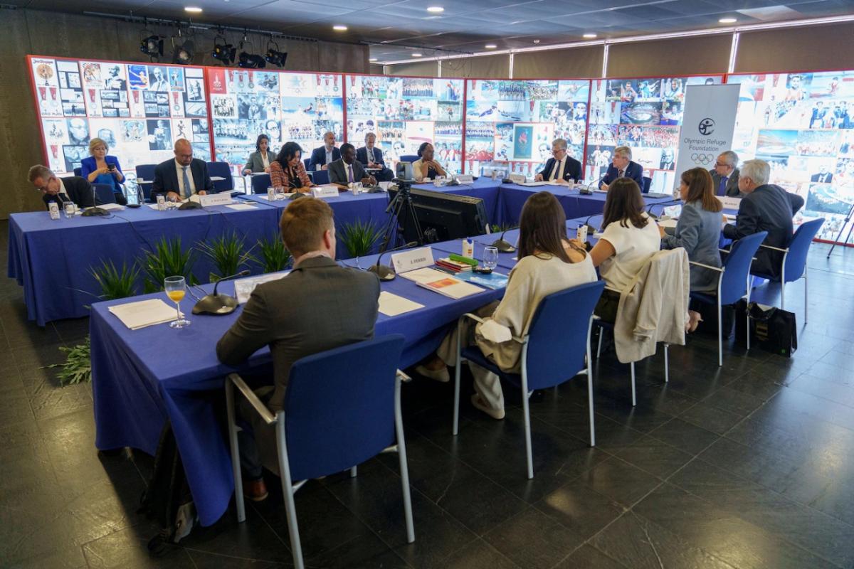 conference of many people seated at a u-shaped table