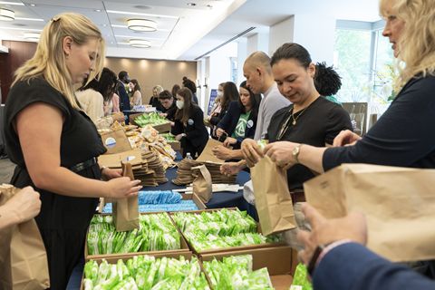 two lines of people assemble bags of period products