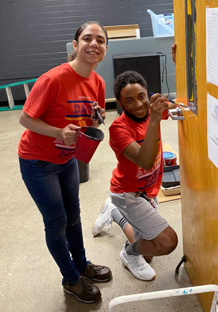 two people with paint and brushes