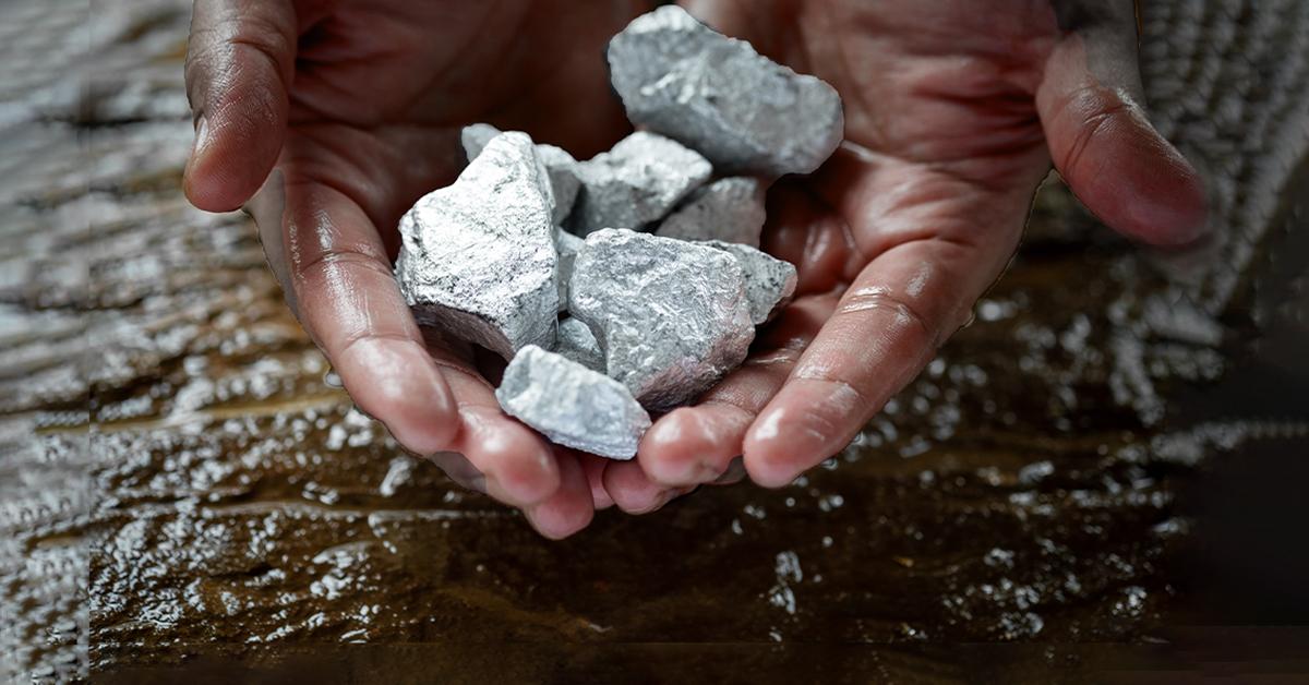 Two hands holding rocks, a wet surface underneath.