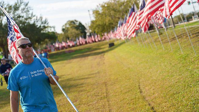 Person holding an American Flag with flags in the background