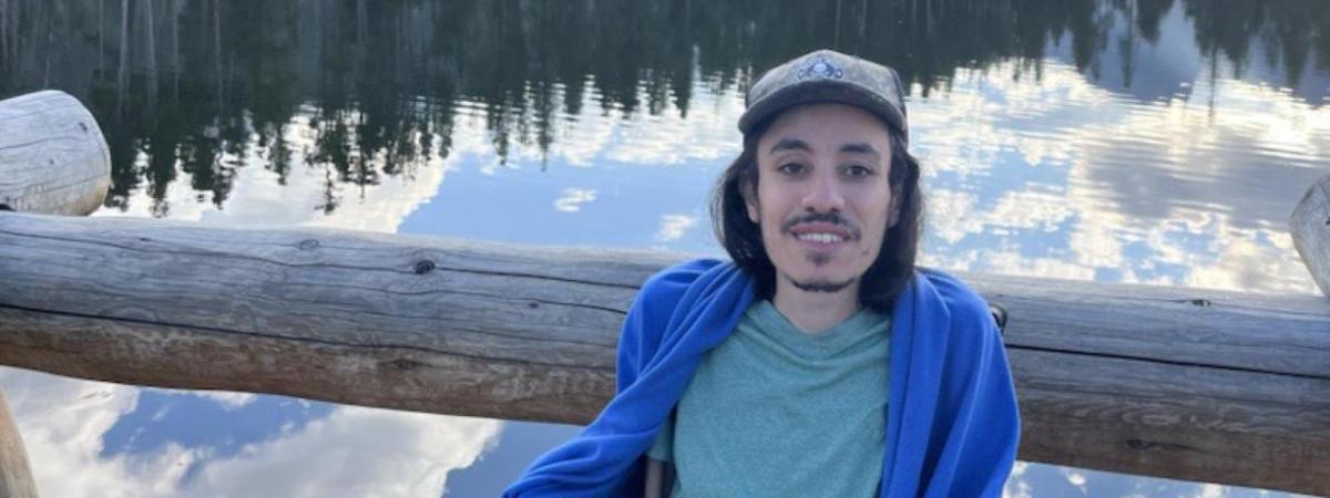 Peter Mansour, a forested body of water behind them.