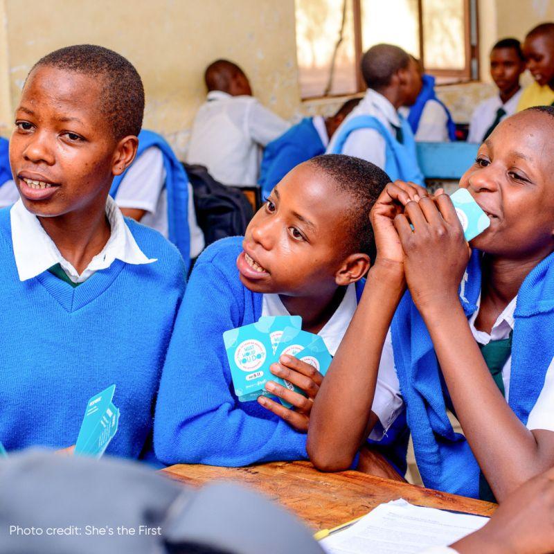 children in school uniforms playing cards