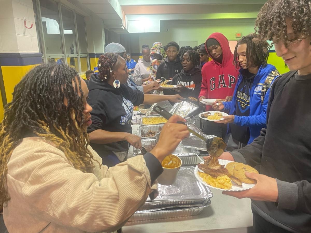 Pittsburgh City League in line for food being served by others.