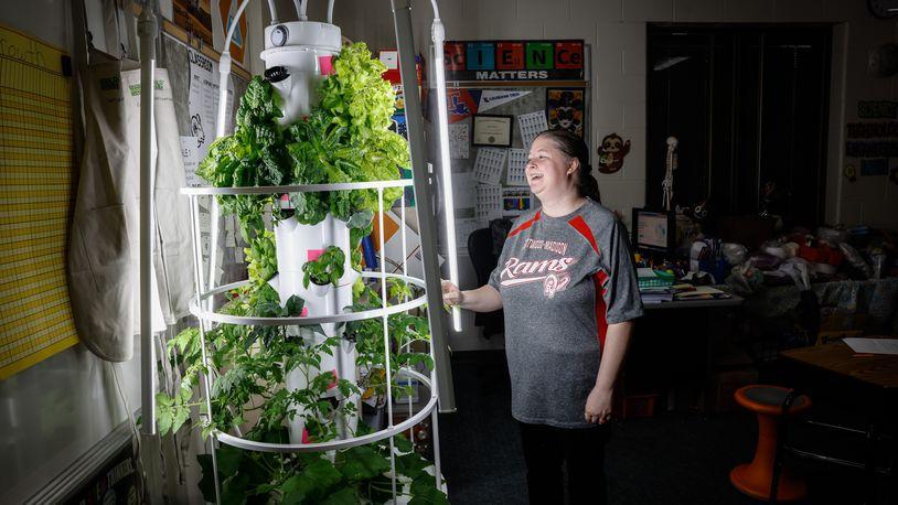 Westbrooke Village Elementary School STEM teacher Daniell Cossey stands next to the grow machine/tower in the classroom. Cossey is implementing agricultural education in her fifth grade classroom through the Green Bronx Machine program. JIM NOELKER/STAFF Image courtesy of Dayton Daily News person looking at plants