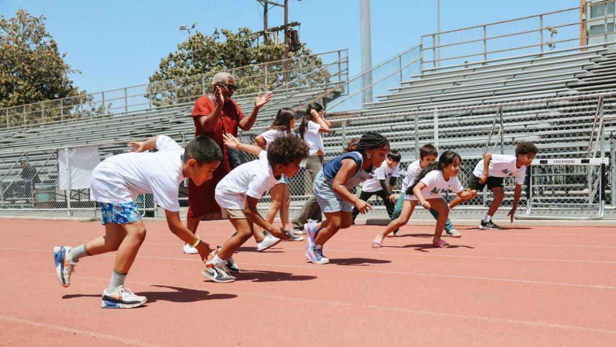 kids sprinting on a clay track