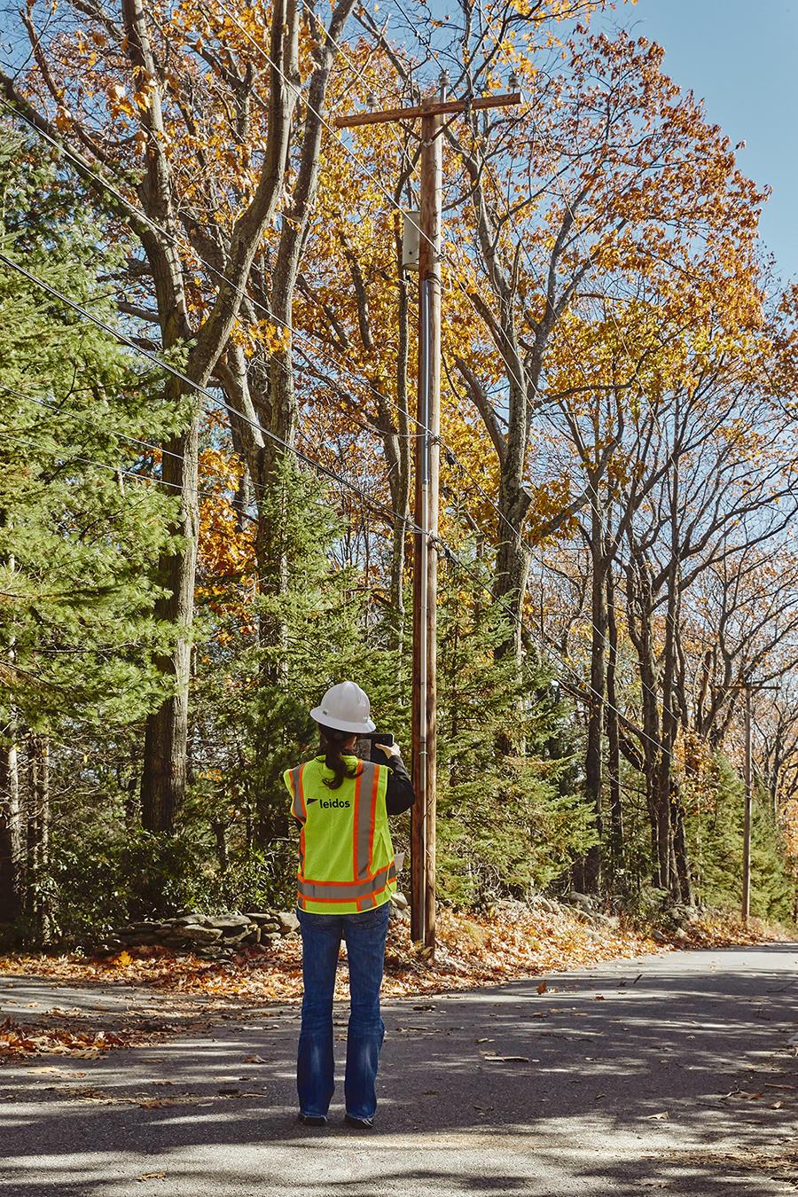Worker looking up at powerlines
