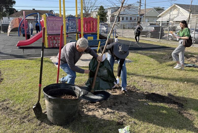 People helping clean up next to a playground