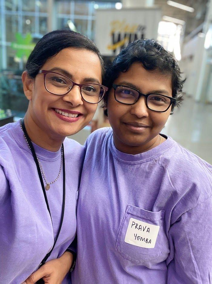 Two people in matching purple shirts