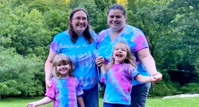 Amber with her wife and two children, all in tie-dye t-shirts