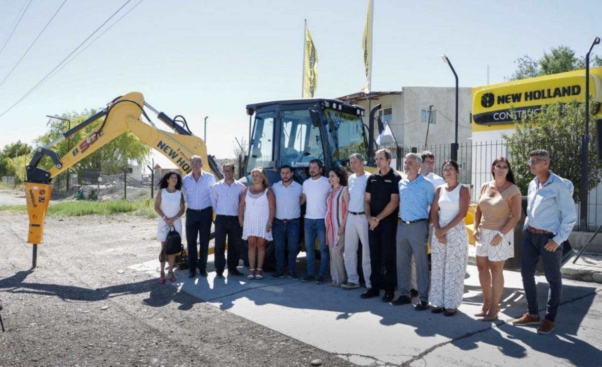 A group of people posed in front of a large construction vehicle