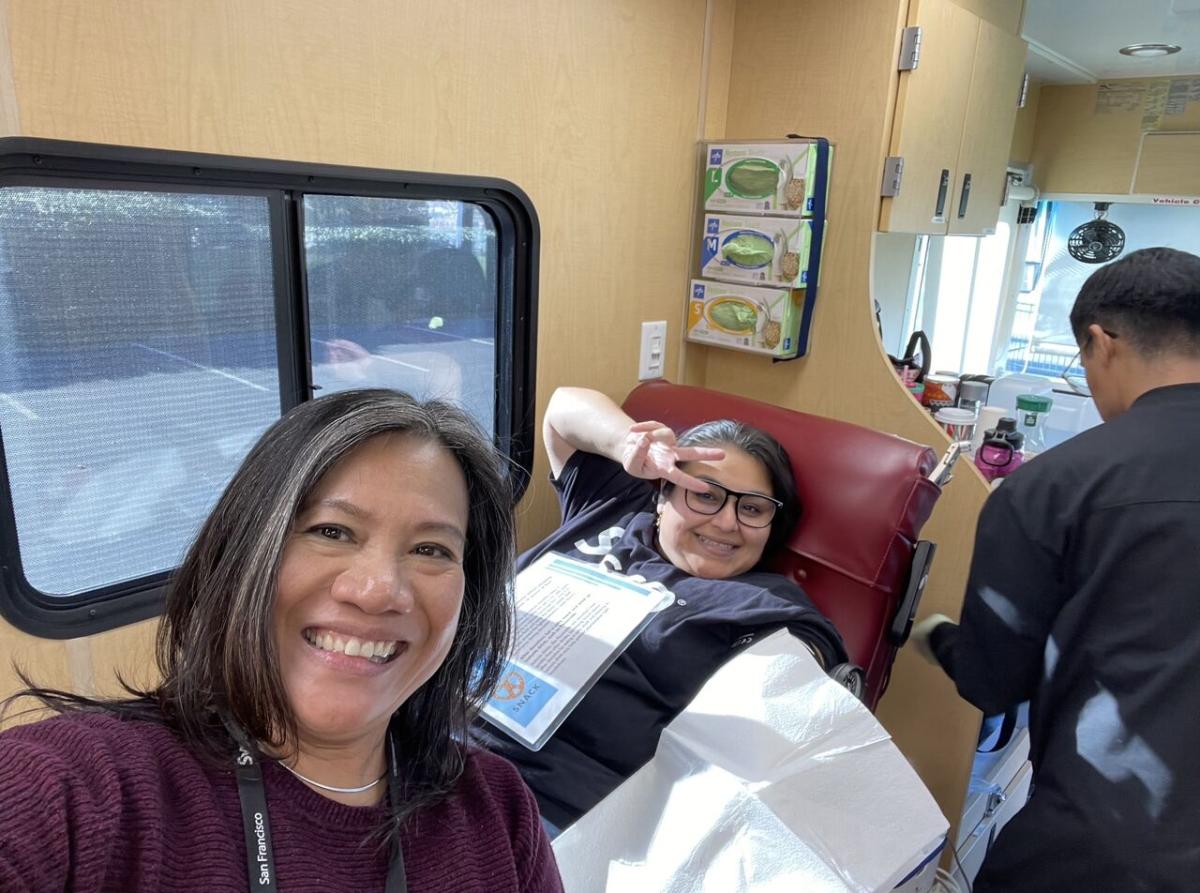 person donating blood with helpers