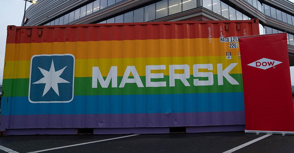 Shipping container painted with rainbow stripes, Maersk and Dow logos on the sides
