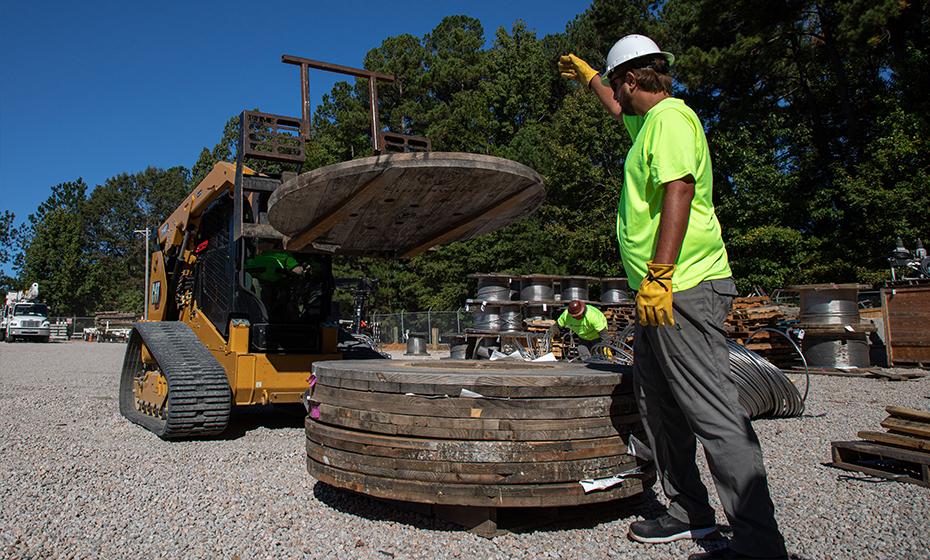 Worker dismantling a wooden spool