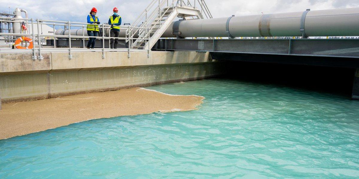 Two employees looking down on water