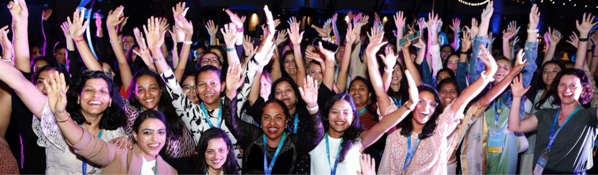 A group of people posed, arms raised.