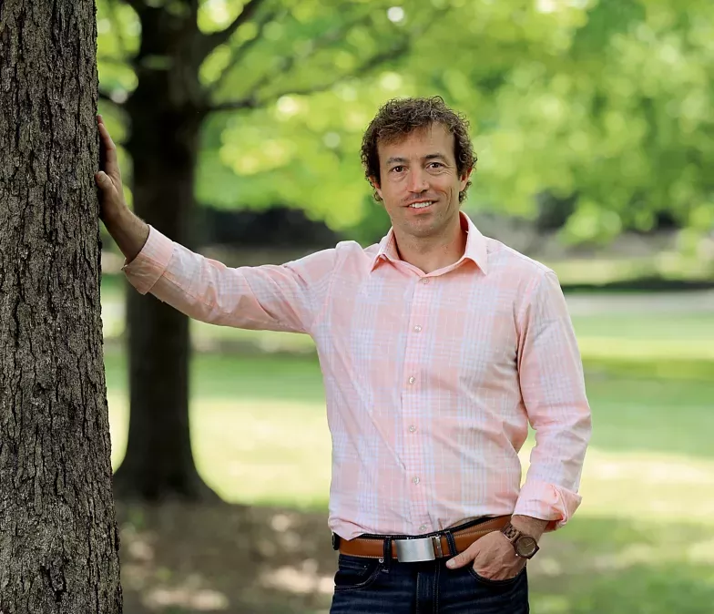 David Brabham stood outside with his hand resting on a tree