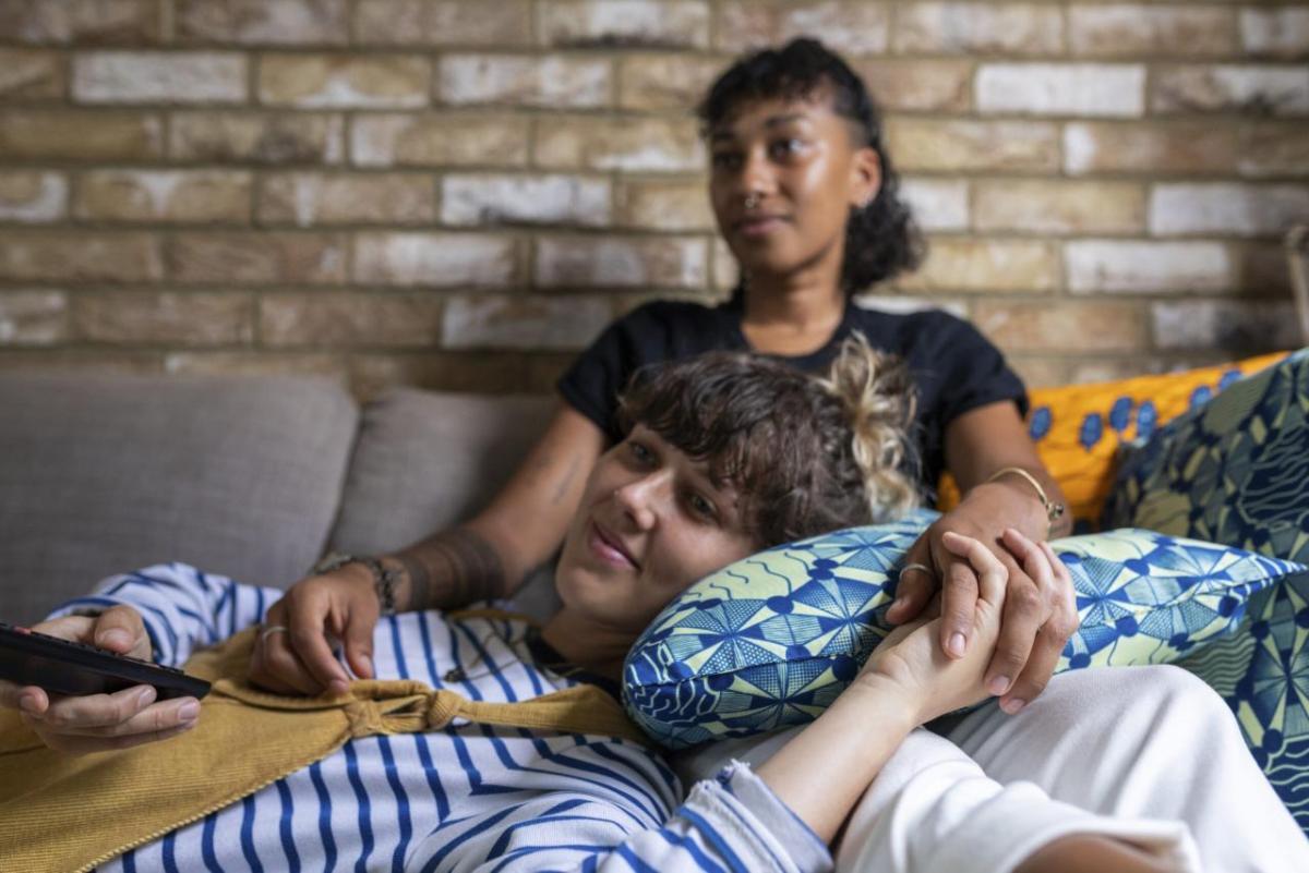 brown skinned couple relaxing on a sofa