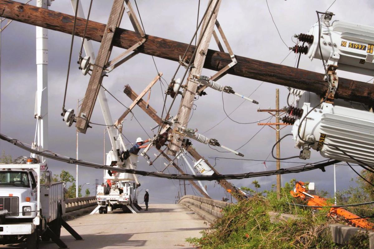 Downed power poles, with Entergy vehicles at work