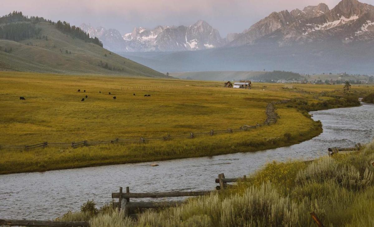 River on a farm with mountains in the background