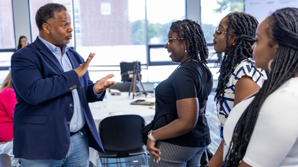 Robert A Winn talking with three others