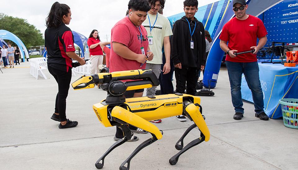 Participants outside watch a robotic animal being operated