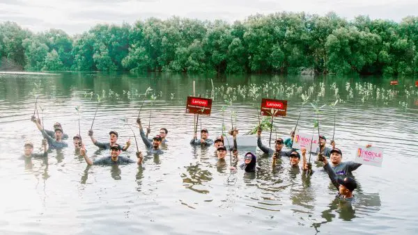 People in a lake holding up signs and branches