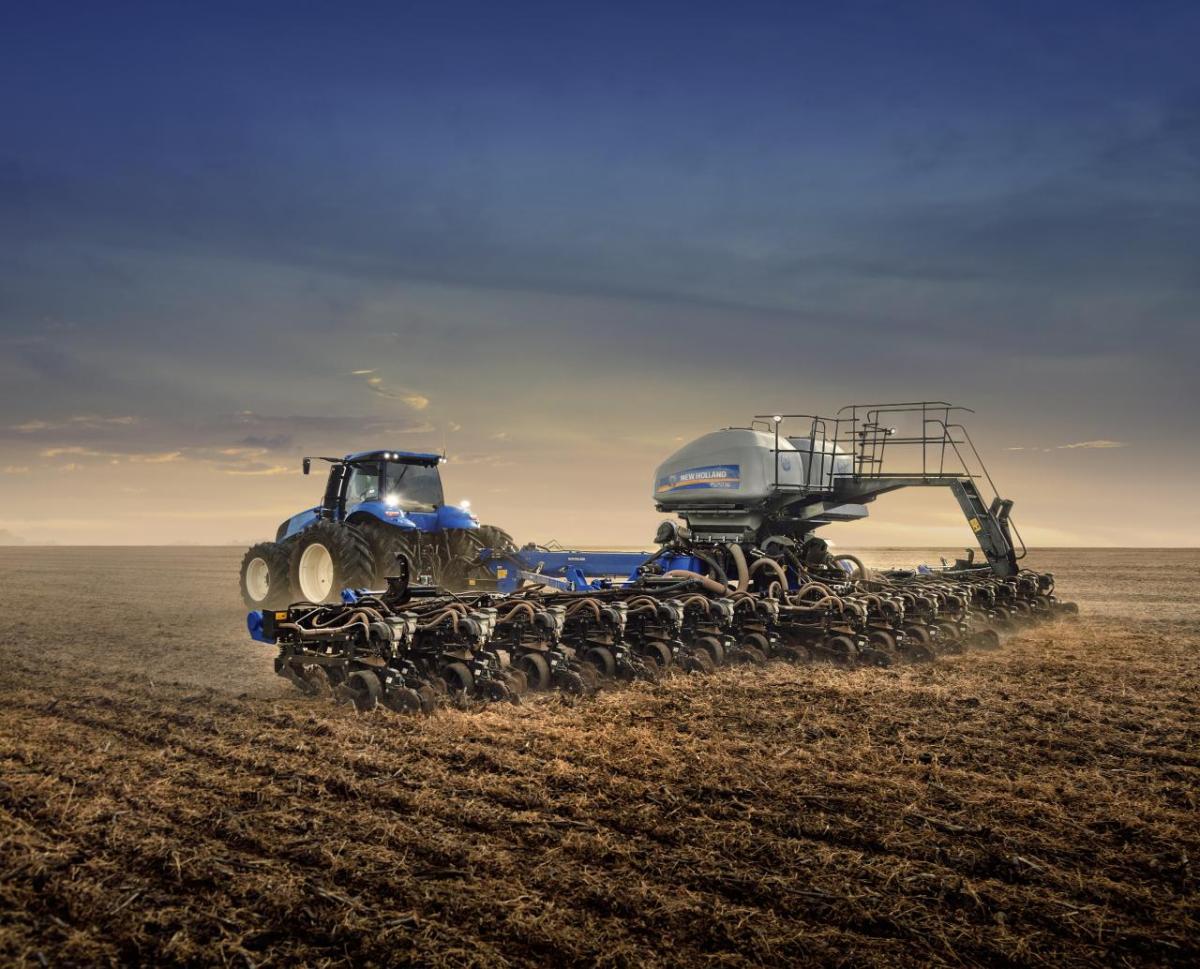 silver tractor in a golden field at dawn