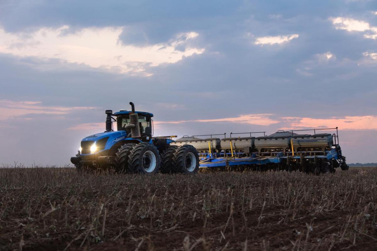 blue tractor in a field at dawn