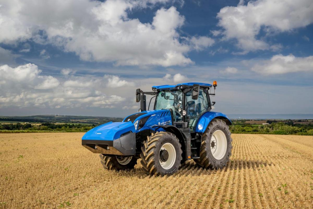 A blue tractor in a crop field.