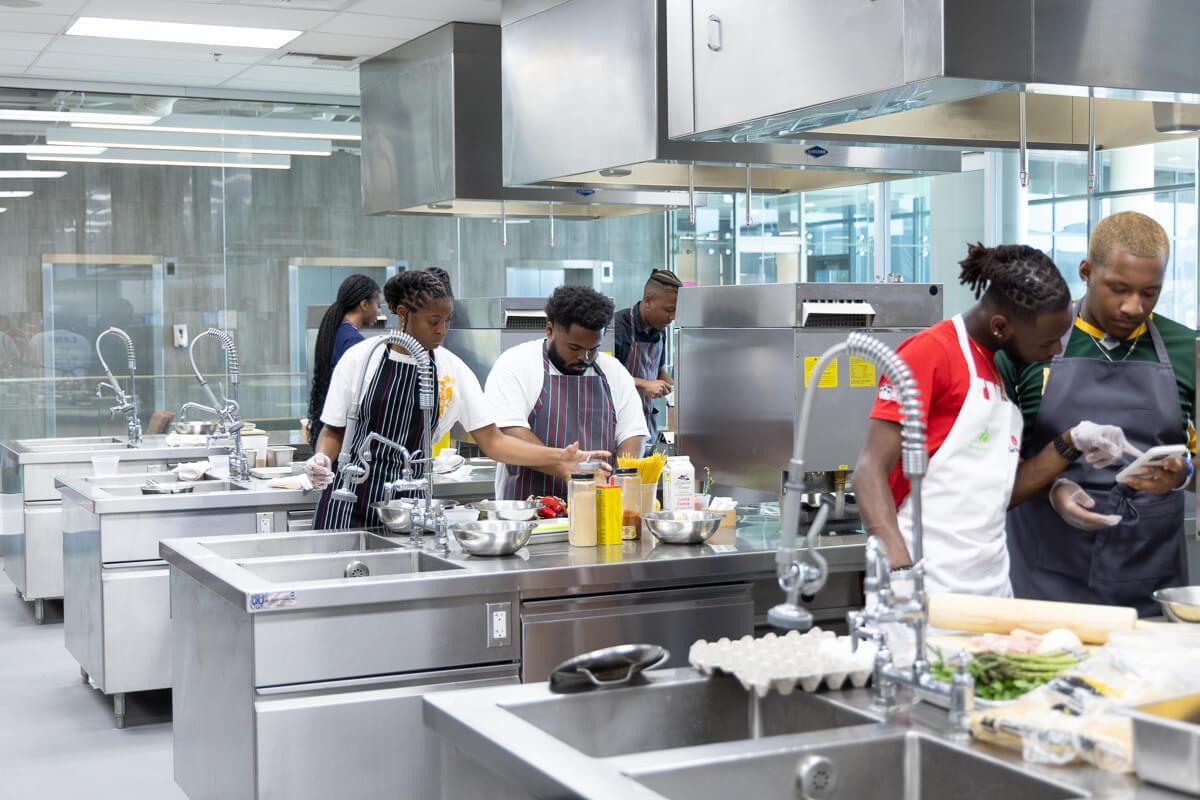 Black culinary students in a commercial kitchen