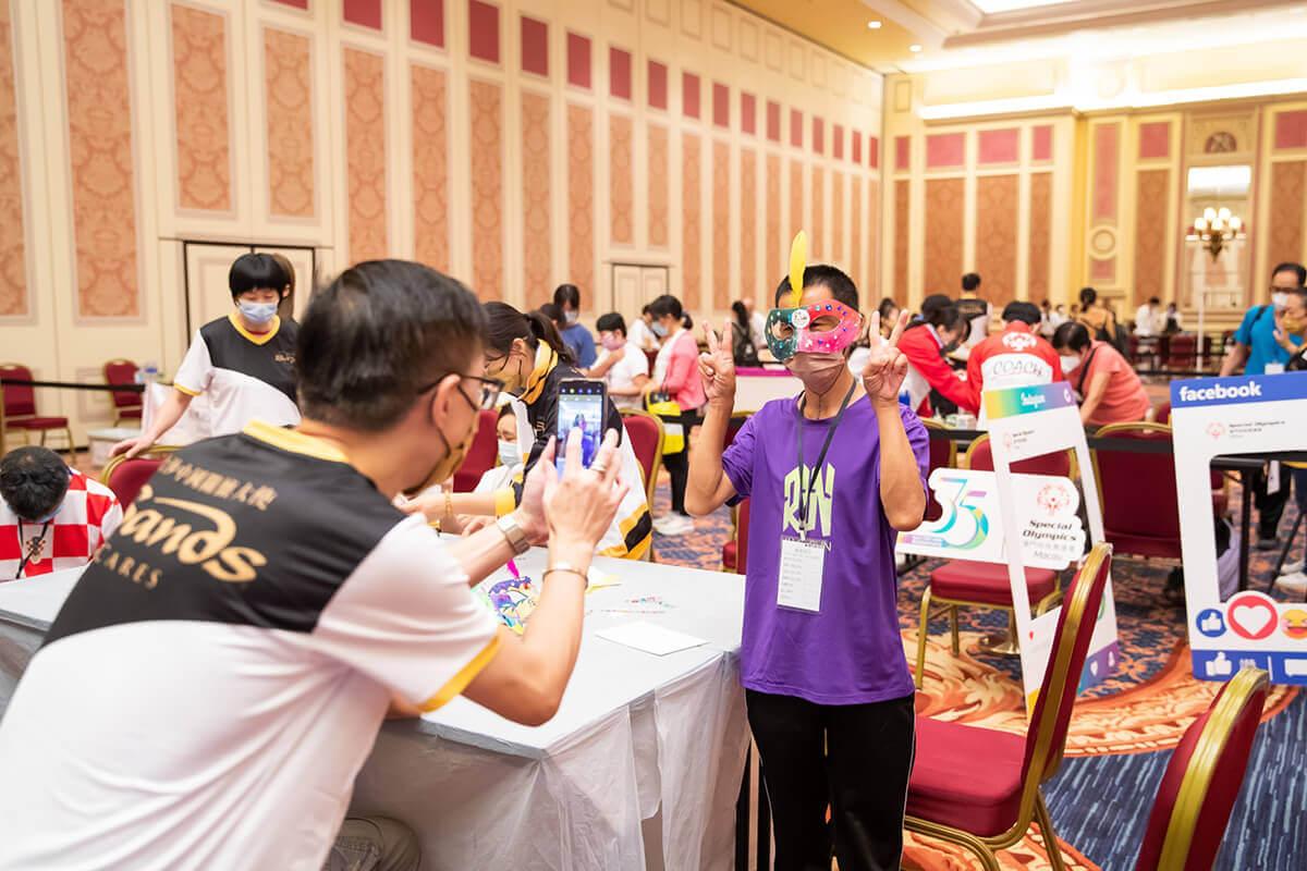 Sands Cares Ambassadors support the Macau Special Olympics' Healthy Athletes Program. One individual taking a photo of another holding up two peace signs