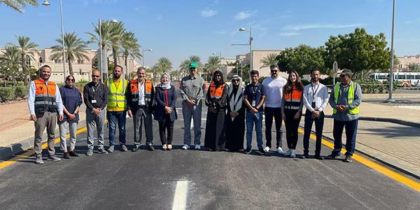 A row of people standing on a road.