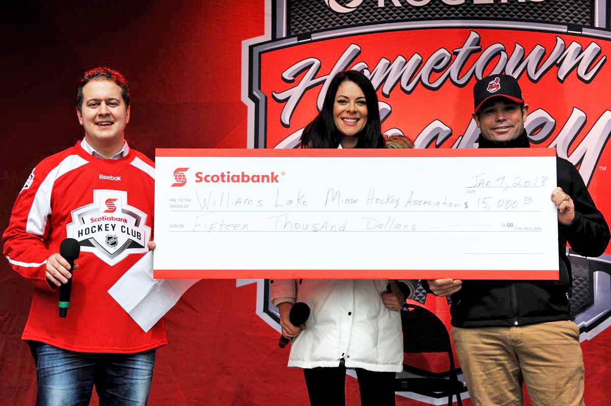 Williams Lake Scotiabank branch manager Aaron Mannella (from left) and Rogers Hometown Hockey co-host Tara Slone present a cheque for $15,000 to Williams Lake Minor Hockey Association president Todd Isnardy Saturday. (Angie Mindus photo)