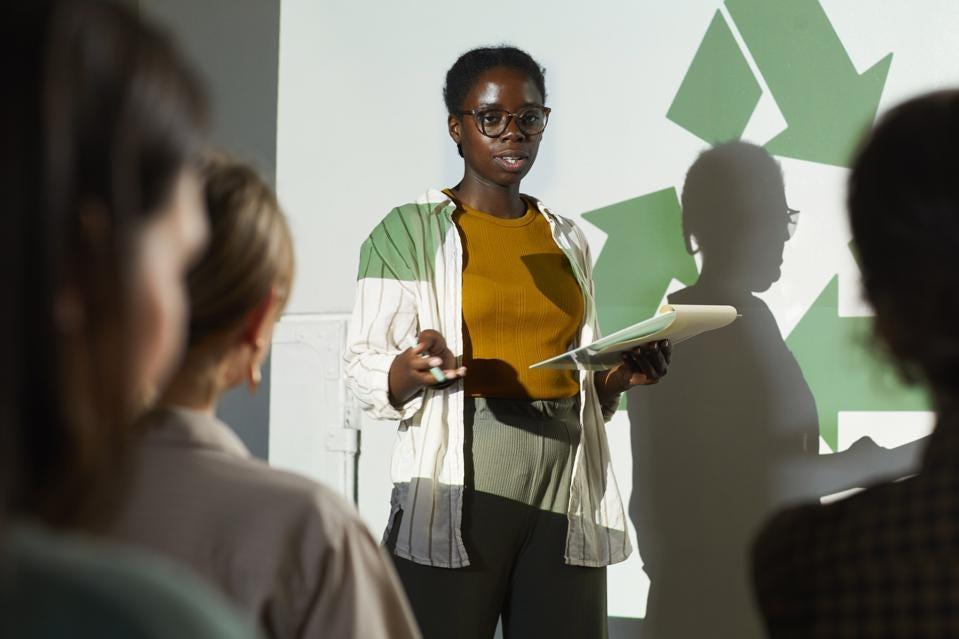 Woman standing in front of a recycling presentation