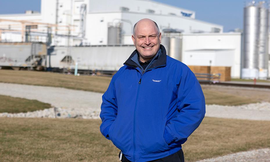 Scott Hickman standing outside a large industrial plant