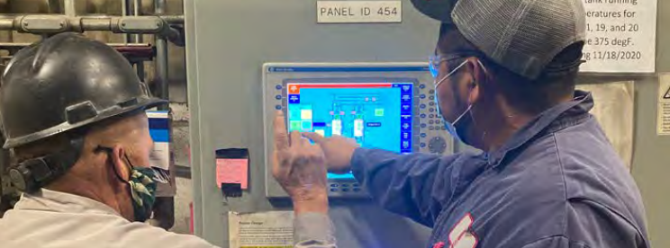 Owens Corning employees at the Houston, Texas roofing plant Rodney Ivy and Margarito Barreto at the Houston plant pointing to screen