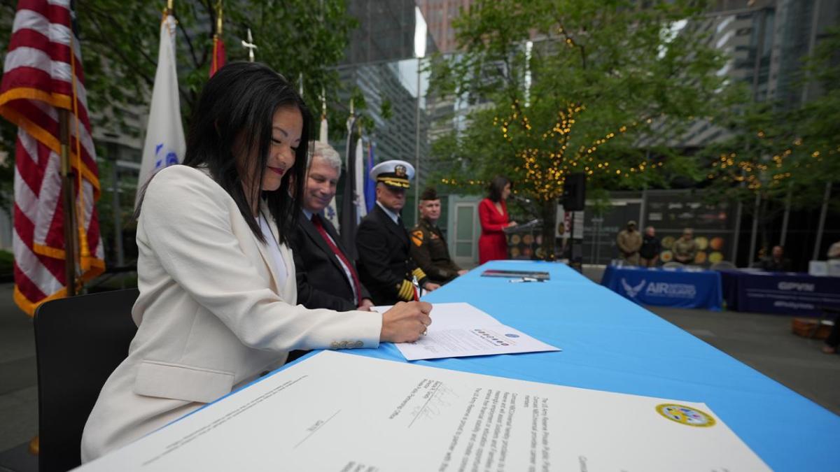 Members of the armed forces signing documents at an event