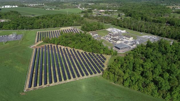Enbridge has constructed a solar self-power facility adjacent to its compressor station in Heidlersburg, Pennsylvania. Field of solar panels next to a campus of building in a forested area