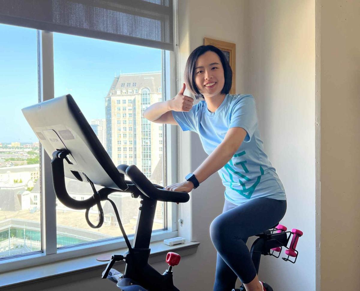 A person giving a thumbs-up on an indoor stationary bike.