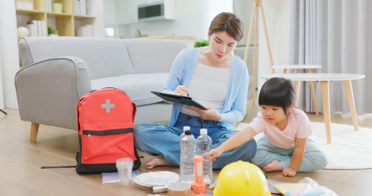 Mother and child checking emergency supplies off a list