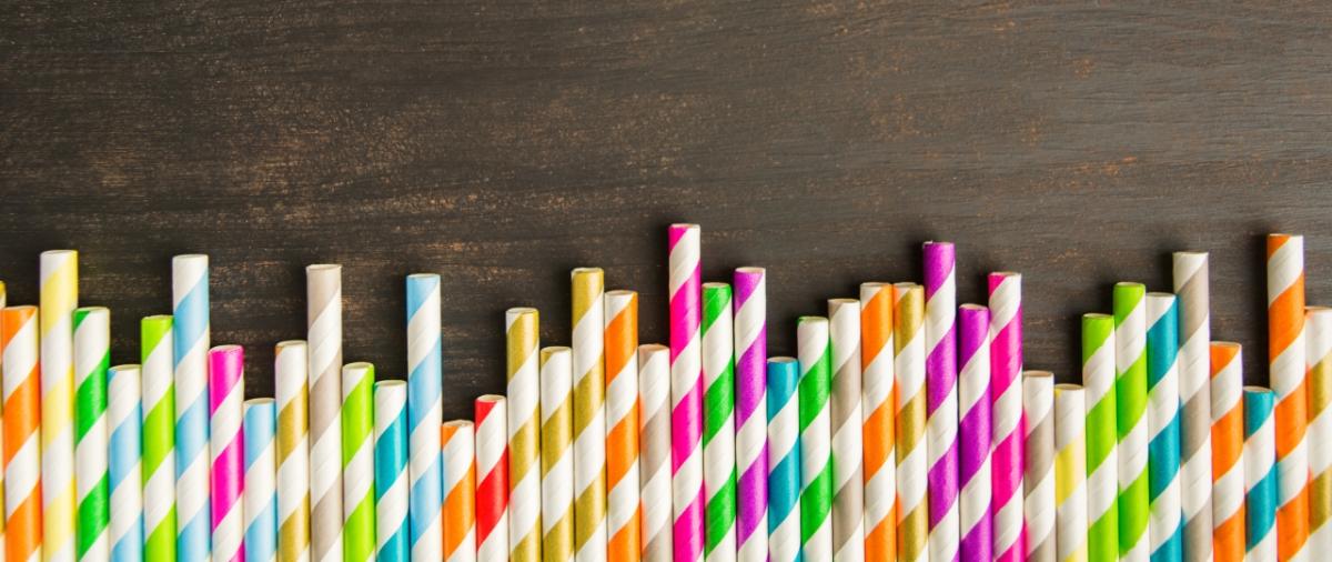 row of striped paper straws on a wood surface