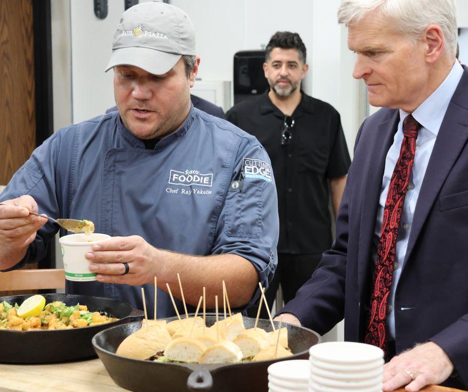Someone dishing out food as the Senator looks on