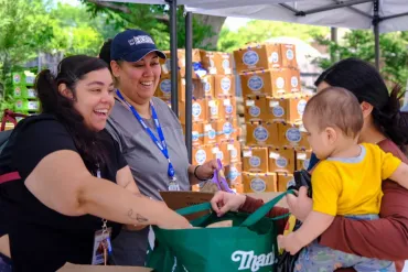 People smiling while filling a grocery bag