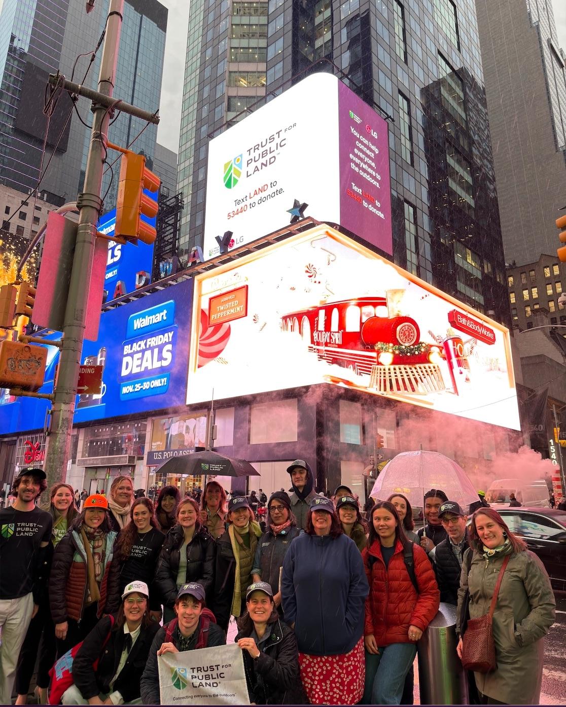 A group posing under a billboard