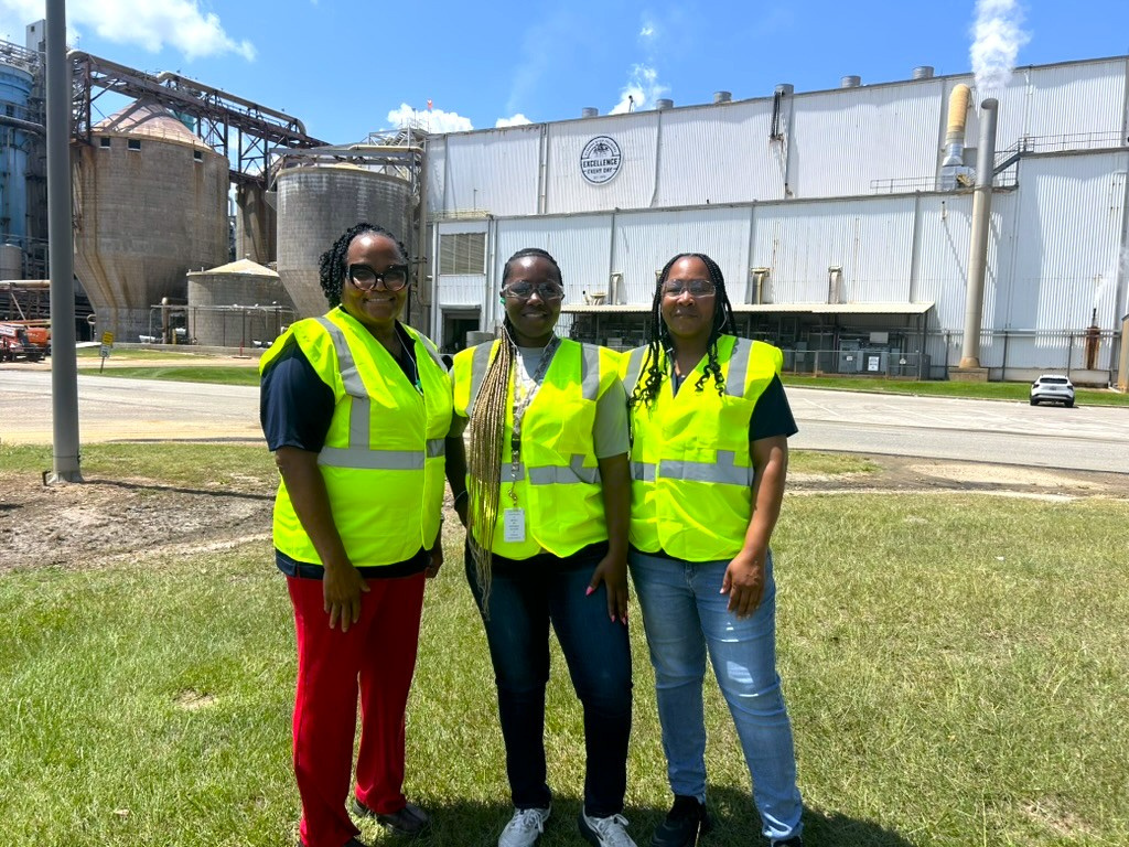 Three people standing in high-vis vests