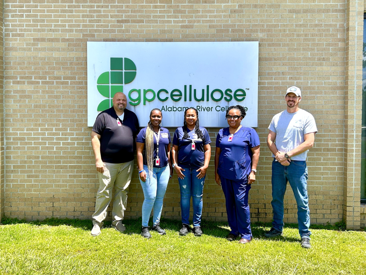 Five people standing in front of a building marked "gpcellulose"