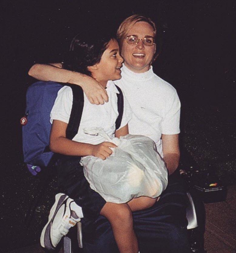 Susan Jolly and a child on her lap carrying a backpack